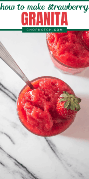 A glass of strawberry granita topped with a fresh strawberry.