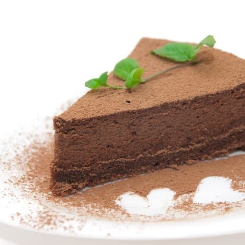 A slice of no-bake chocolate cheesecake on a white plate.