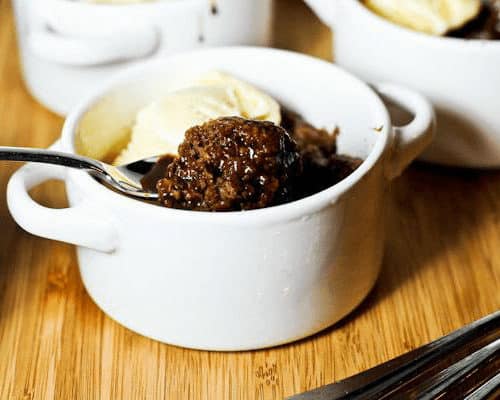 A cup of southern chocolate cobbler with ice cream and a spoon in it.