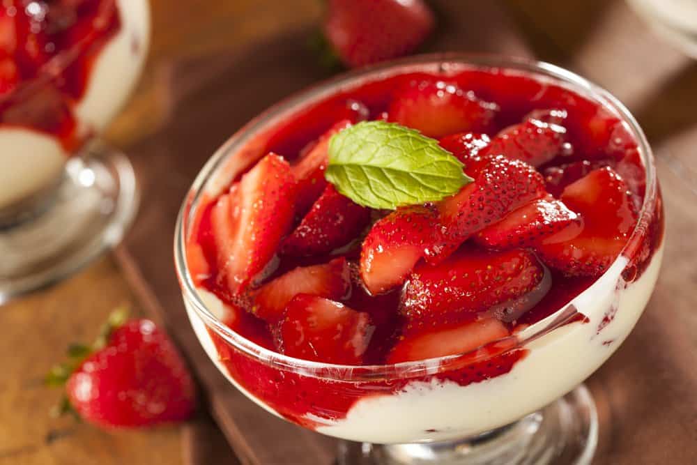 A glass of fresh strawberry parfait dessert.