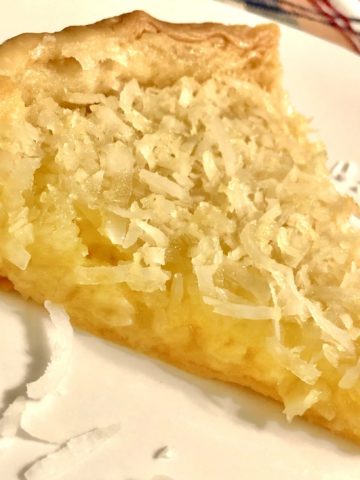 A slice of French coconut pie on a white plate.