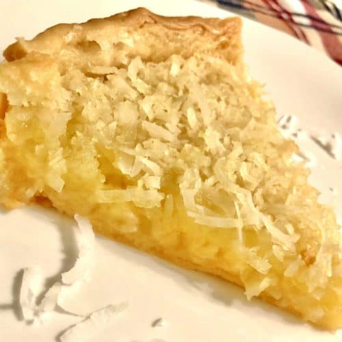 A slice of French coconut pie on a white plate.