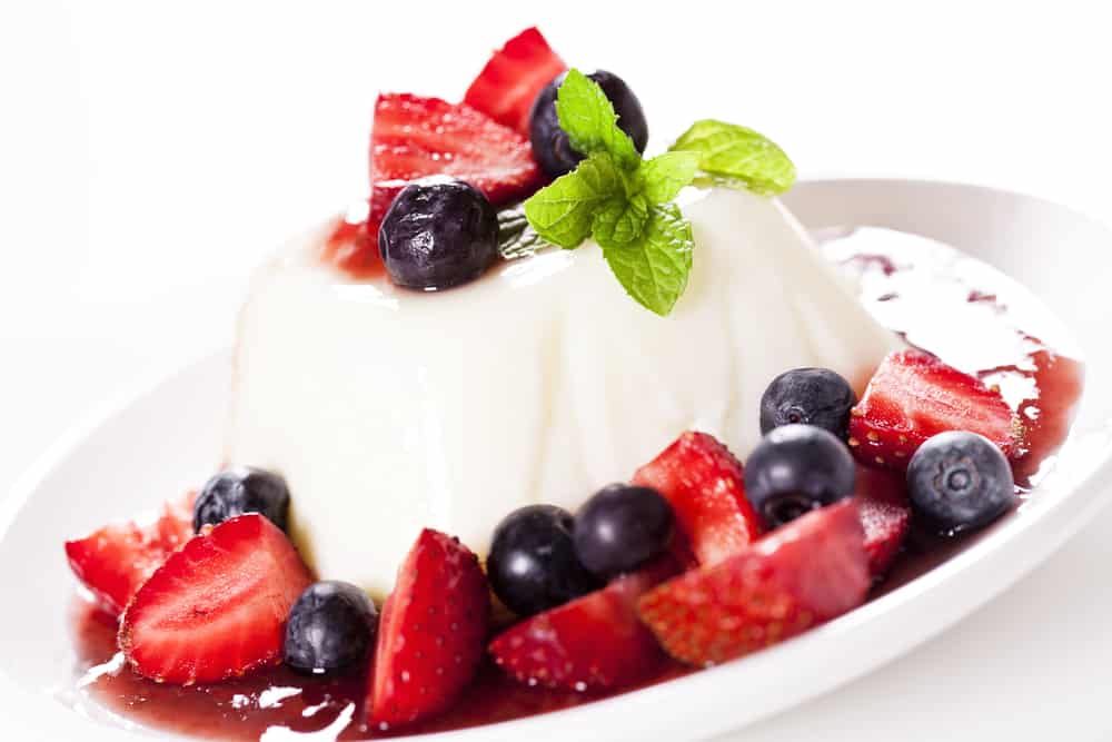 Panna cotta dessert recipe on a plate with strawberries.