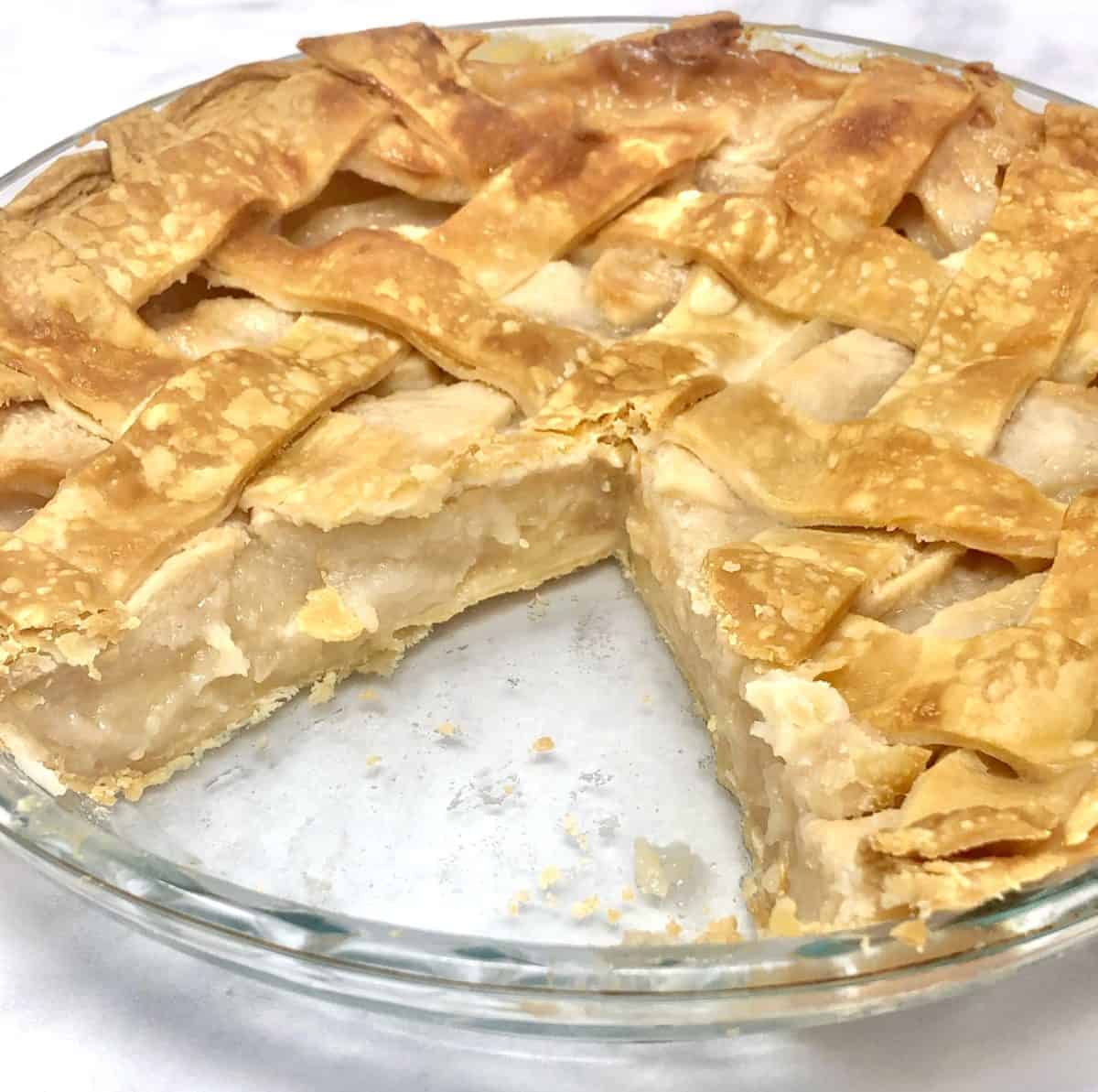 A homemade apple pie with a slice missing from it.