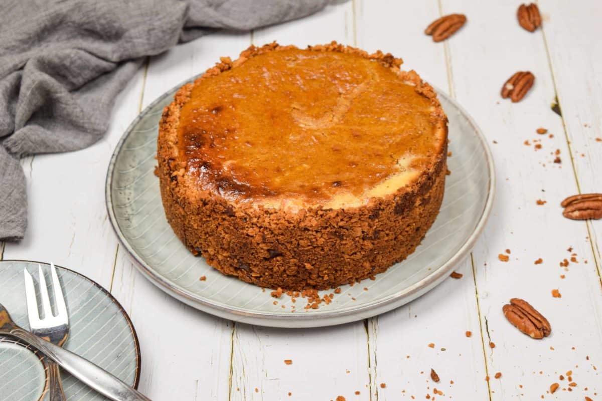 A gingersnap pumpkin cheesecake in a dish on the table.