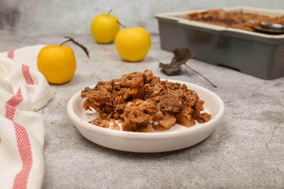 A bowl of old fashioned apple crisp on a table.