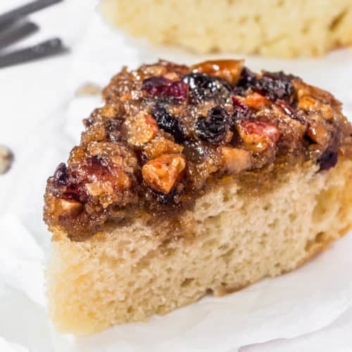 A slice of sour cream cranberry coffee cake on a table.