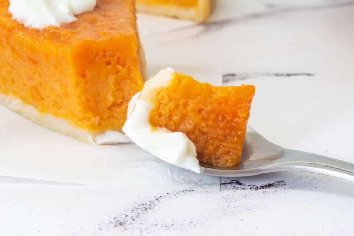 A close up of sweet potato pie on a spoon.