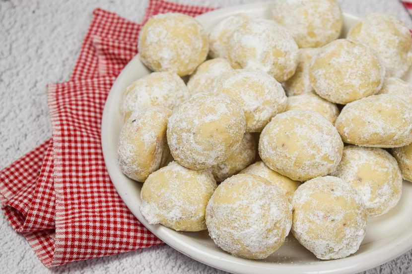 A bowl of snowball cookies with pecans.
