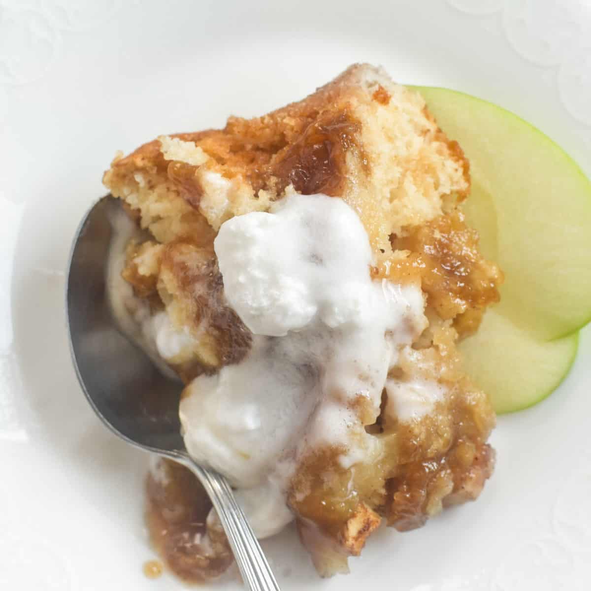 A close up of apple cobbler in a spoon.