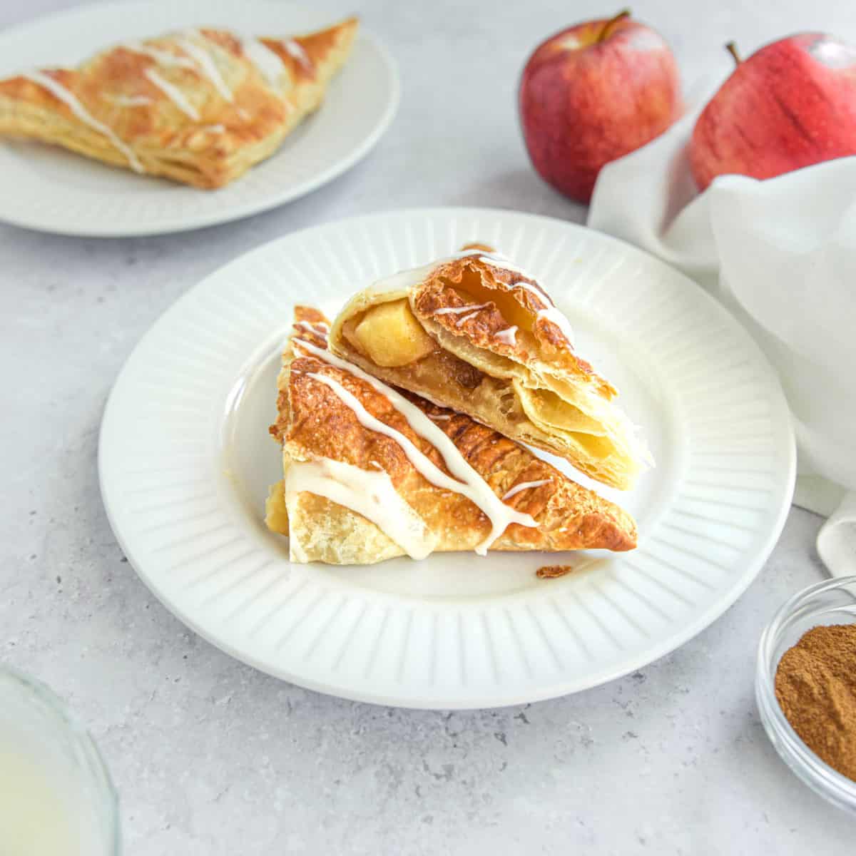 Apple turnovers with fresh apples in the background.