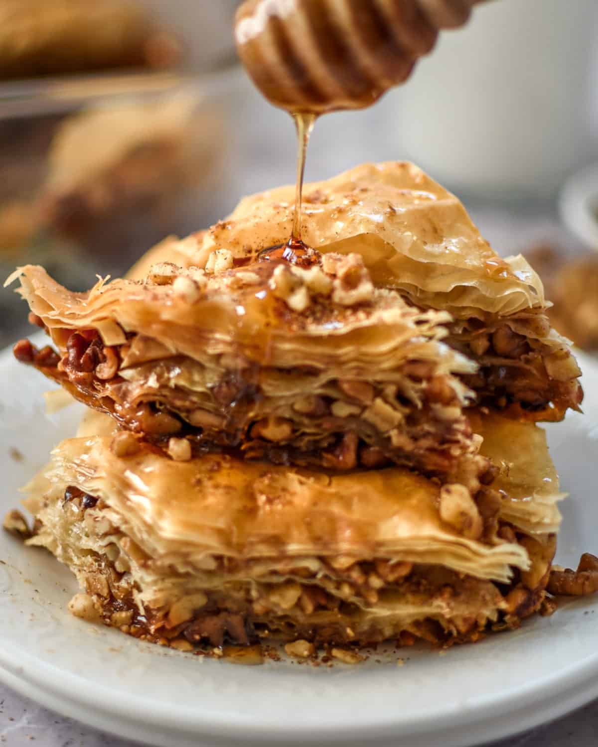Pouring honey over two slices of baklava.
