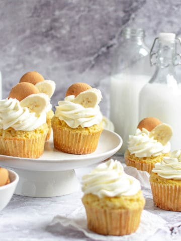 Several banana cream cupcakes on a cake stand.