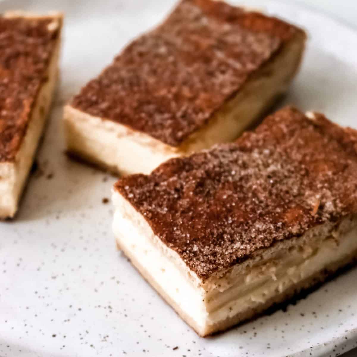 A close up of slices of churro cheesecake.
