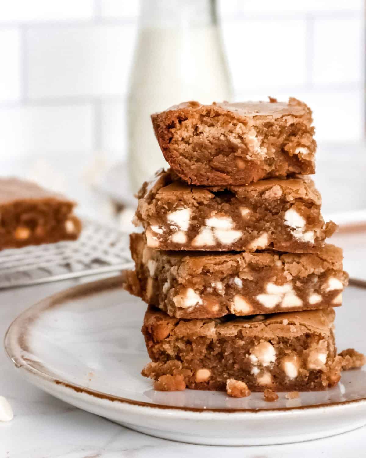 A stack of blondies with white chocolate chips in them.