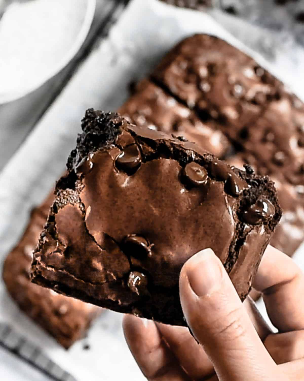 A finished brownie being held close up.