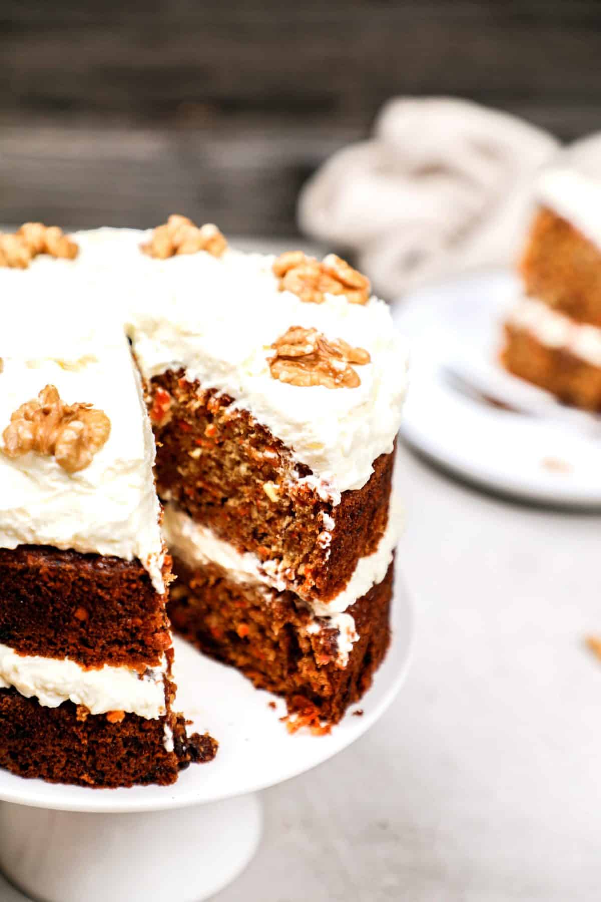 A carrot cake with a slice cut out showing the inside.