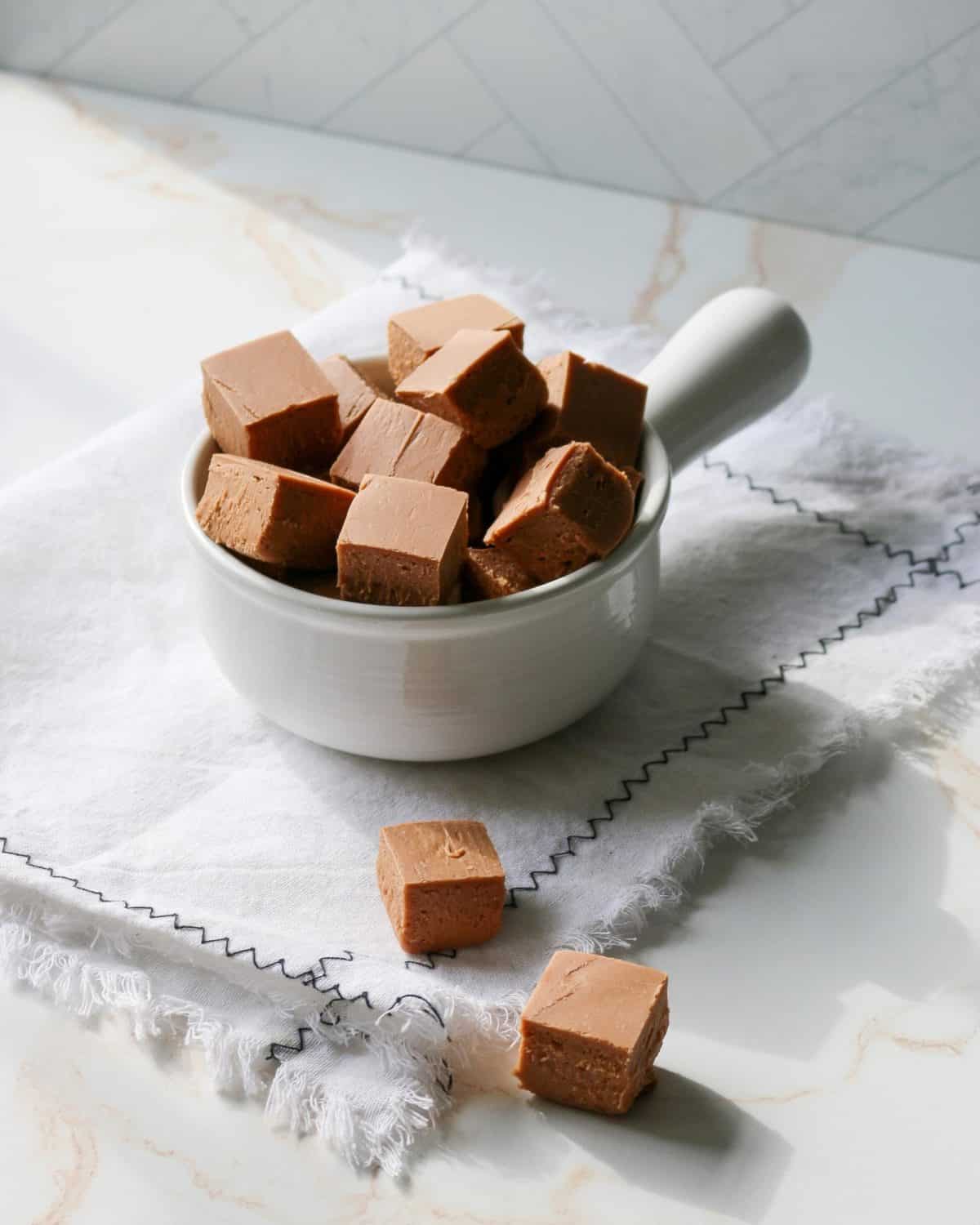 A bowl of several square pieces of fudge.