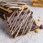 Chocolate covered graham crackers with white chocolate drizzle.
