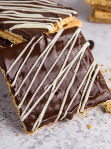 Chocolate covered graham crackers with white chocolate drizzle.