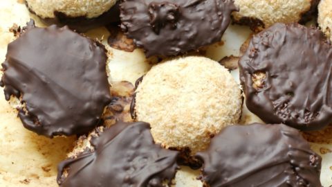 Several chocolate-dipped coconut macaroons on a table.
