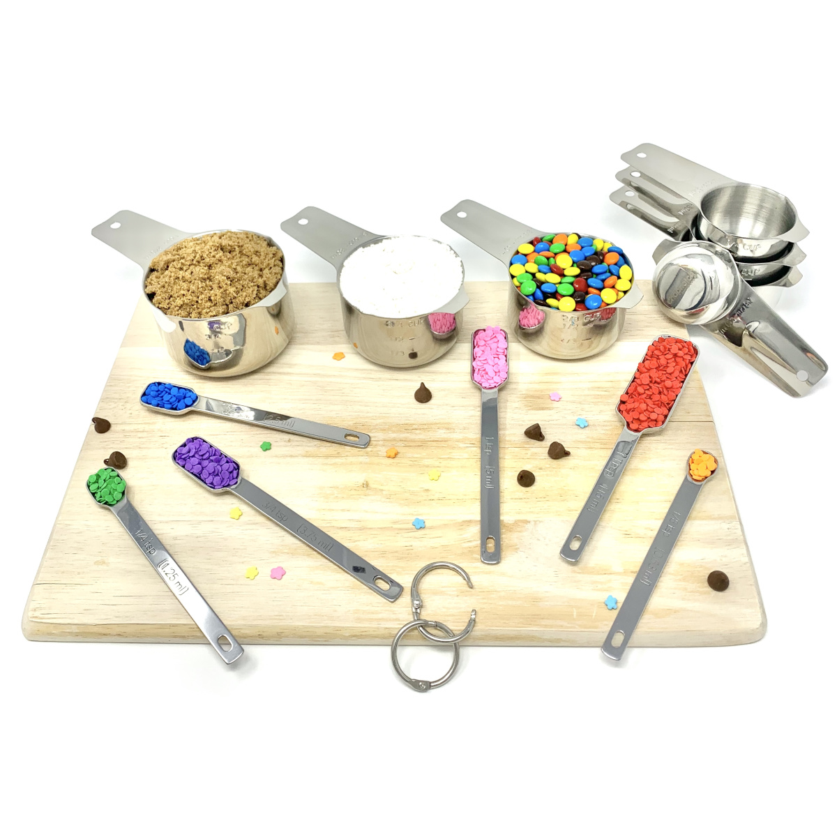 The complete measuring set on a cutting board with baking ingredients.