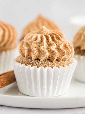 A cinnamon cupcake up close on a white plate.