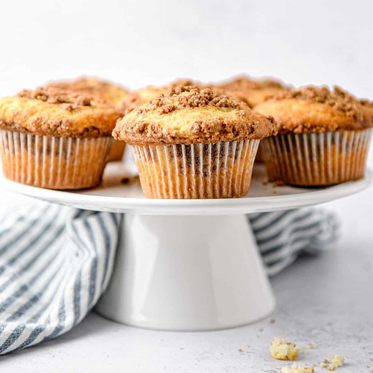 Cinnamon streusel muffins on a stand.