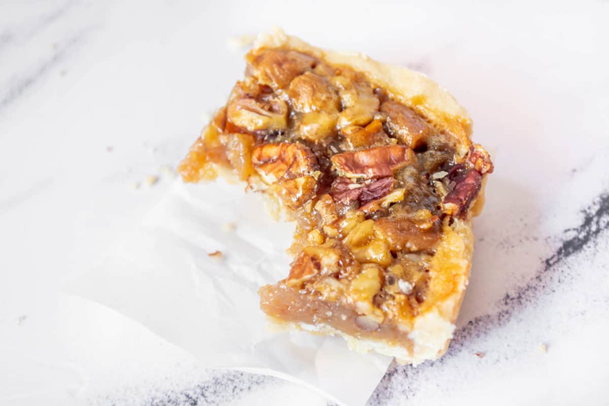 A classic pecan pie bar with a bite taken out of it.