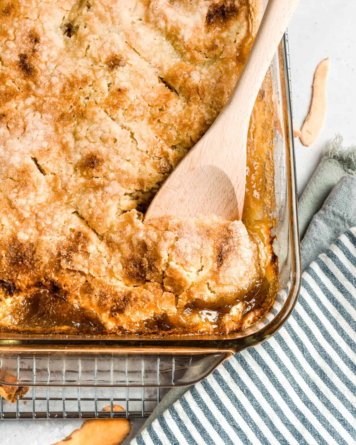 Cobbler in a baking dish with a wooden spoon.