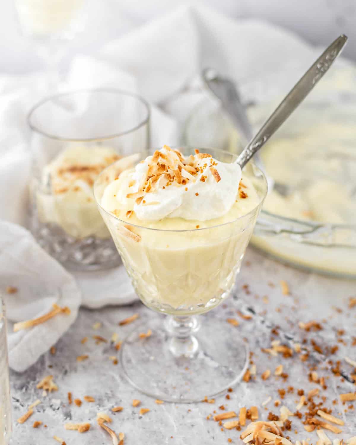 Coconut pudding in a glass with a spoon.