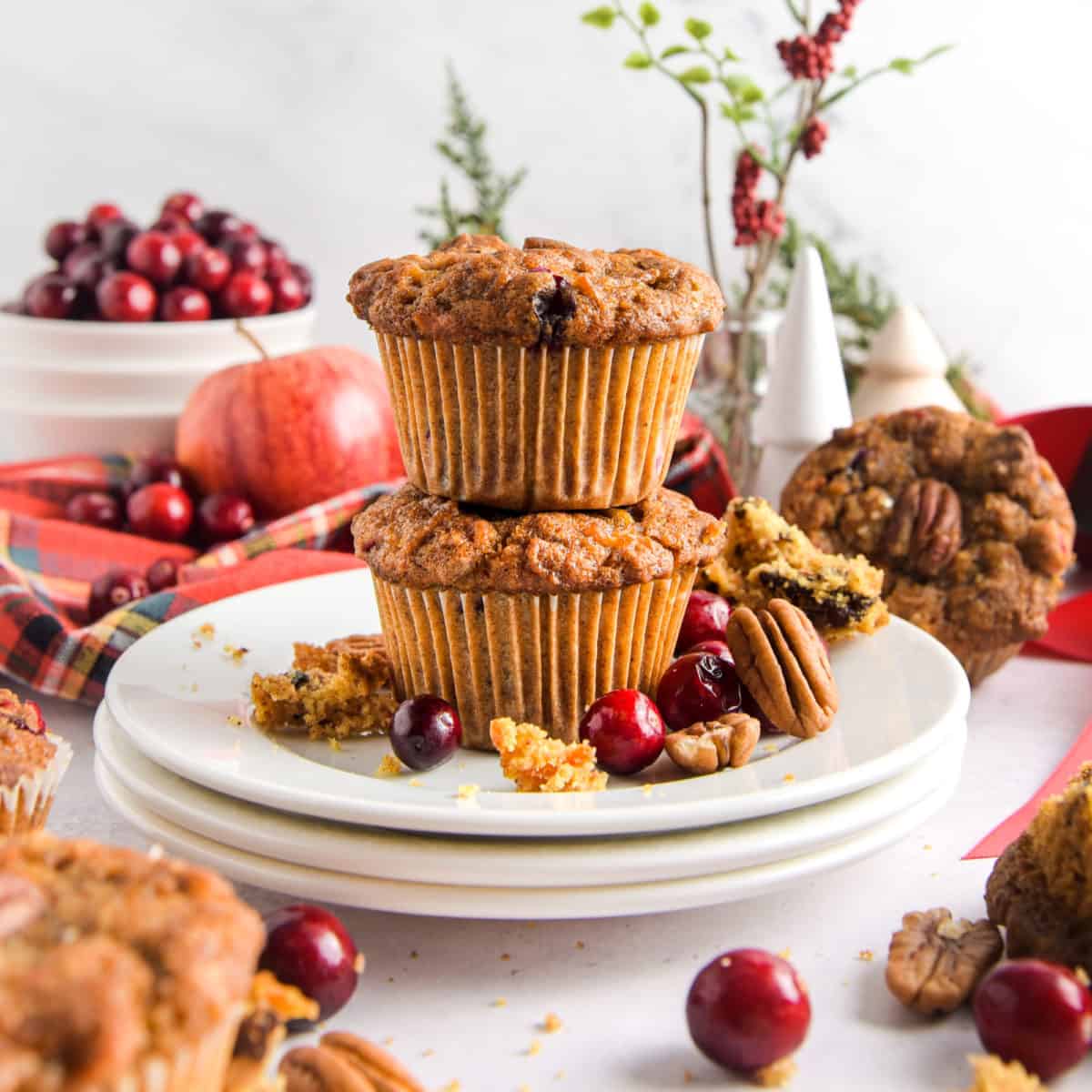 Two cranberry apple muffins on a white plate.