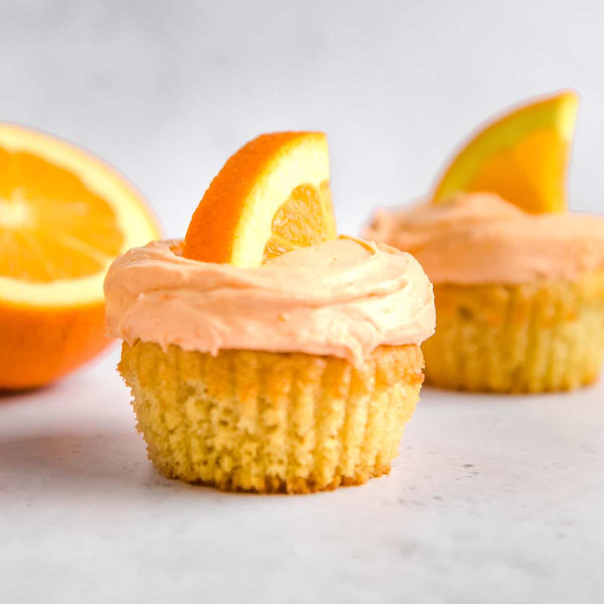 A cupcake with orange frosting.