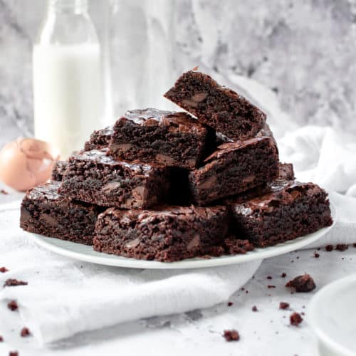A pile of dairy free brownies in a plate.