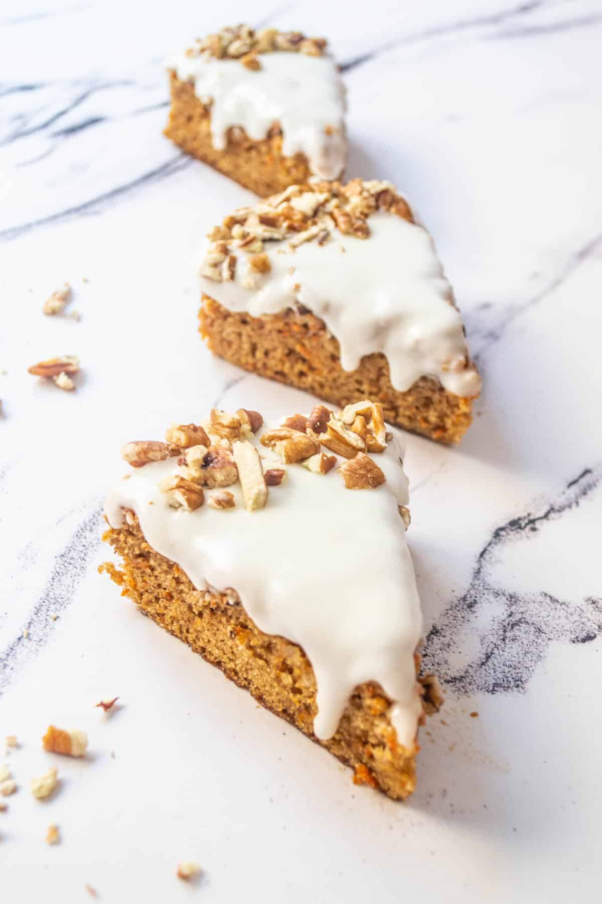 Several slices of dairy free carrot cake on a table.