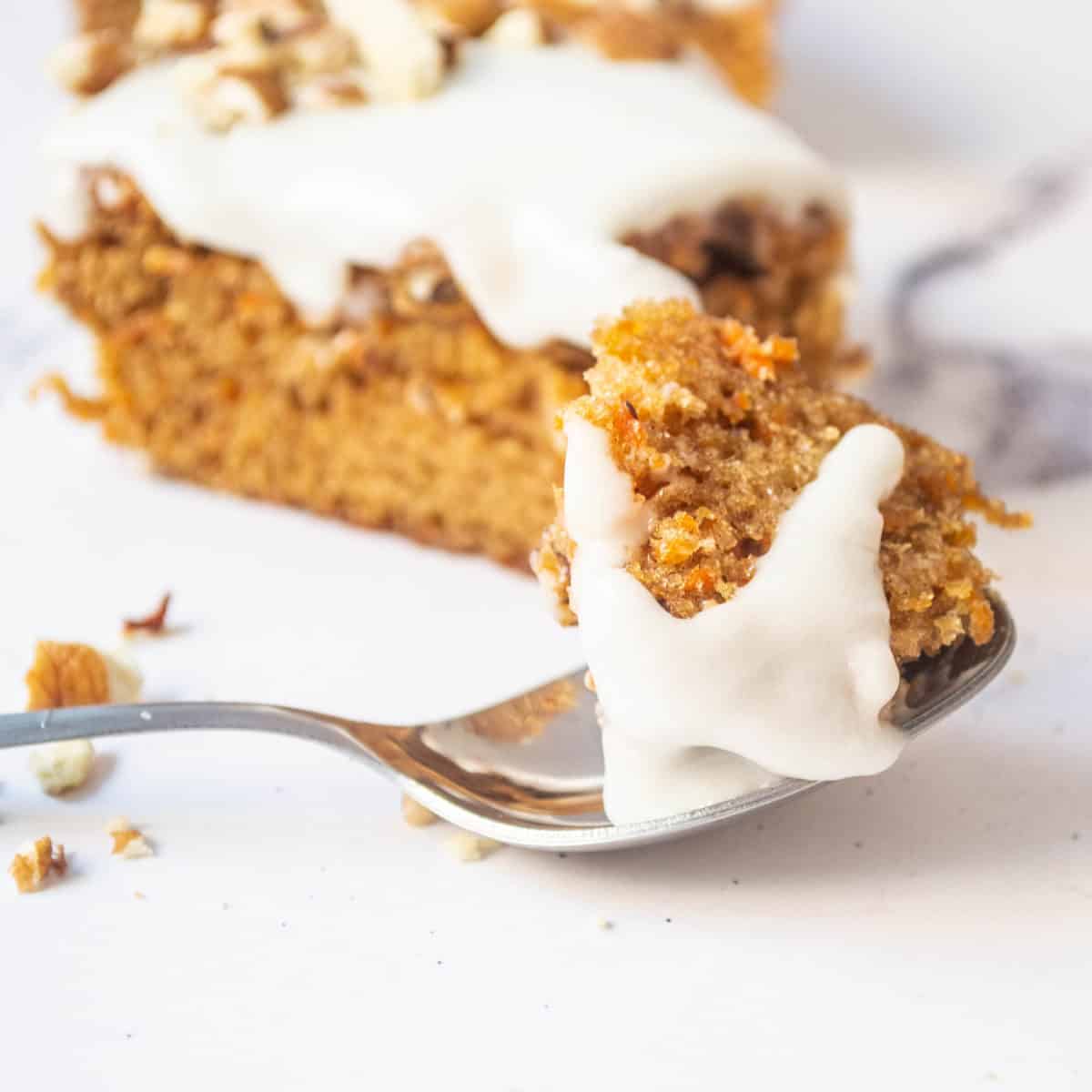 A spoonful of carrot cake with glaze.