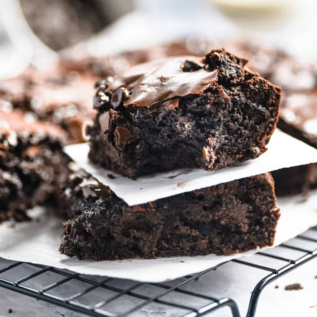 Two dark chocolate brownies stack on top of each other.