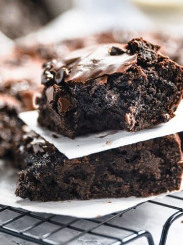 Two dark chocolate brownies stack on top of each other.
