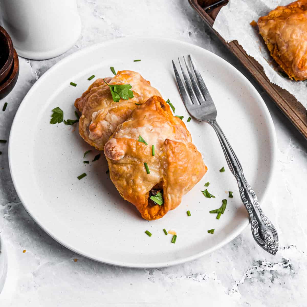 Two egg puffs on a plate with a fork.