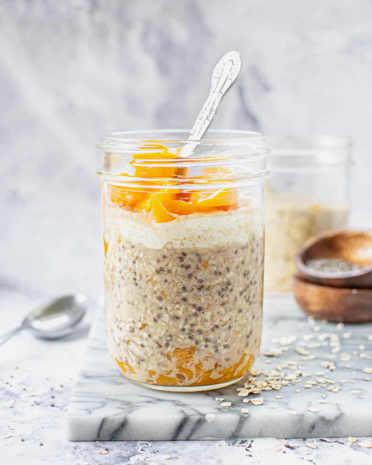 Overnight oats in a glass with a spoon in it.