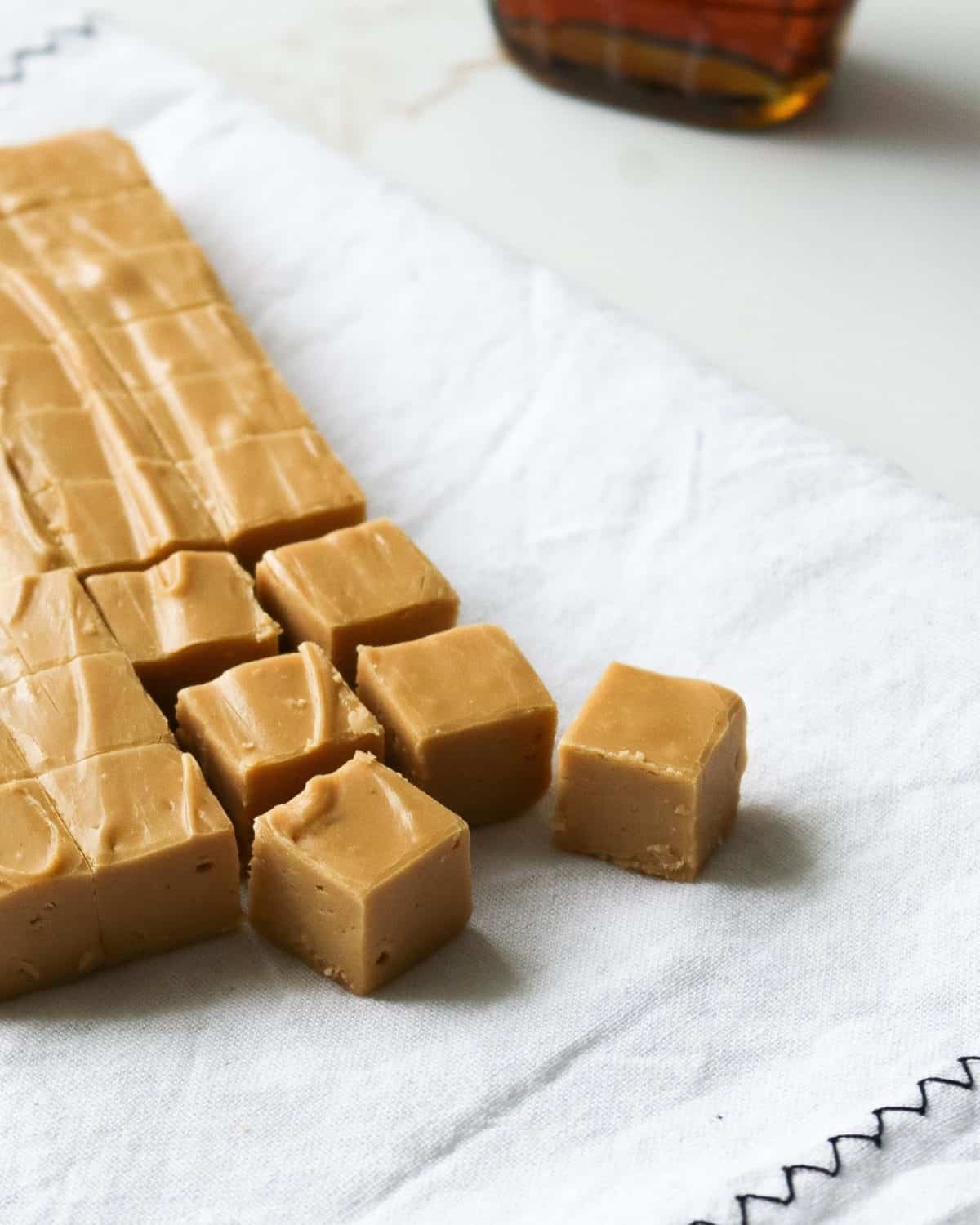 A block of fudge being cut into smaller squares for serving.