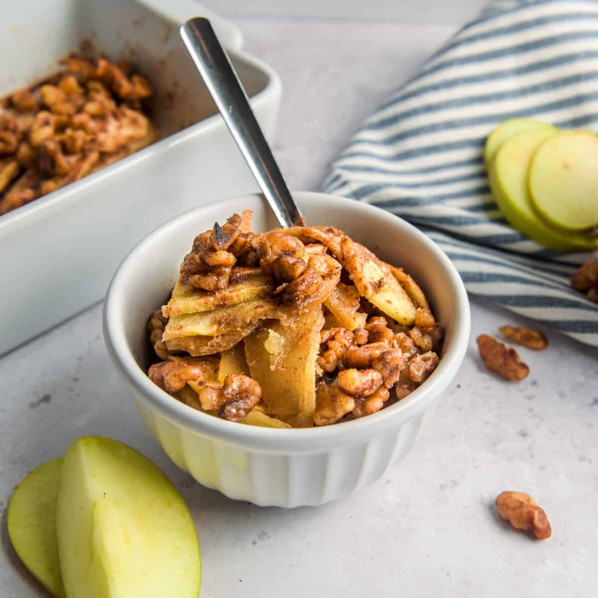 A bowl of keto apple crisp with a spoon in it.