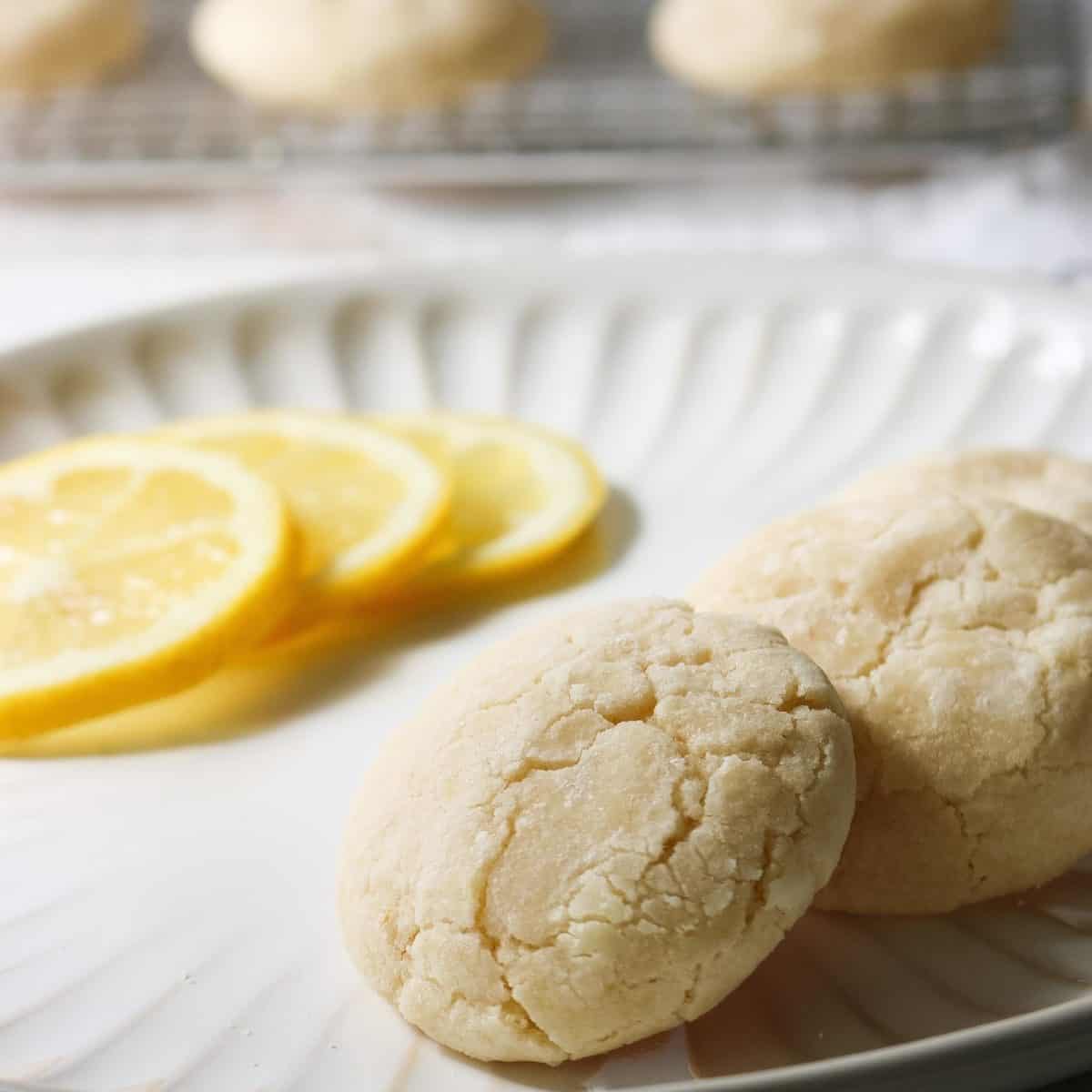 A close up of fresh cookies with lemon slices in the background.