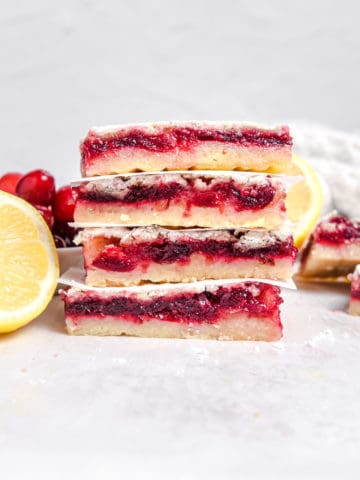 Four lemon cranberry bars stacked on top of each other.