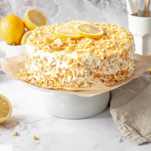 A lemon crunch cake on a cake stand.