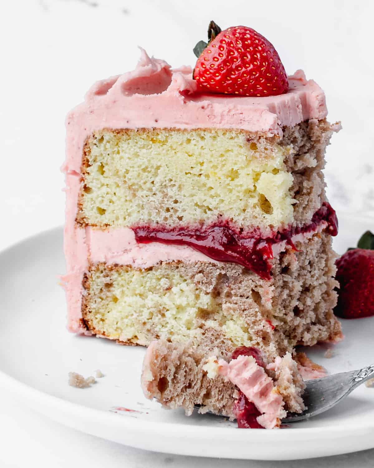 A bite of lemon strawberry cake up close.