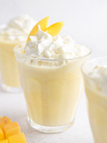 A mango milkshake with whipped cream.