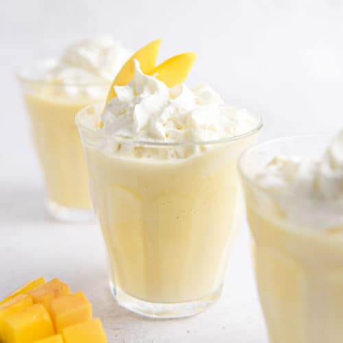 A mango milkshake with whipped cream.