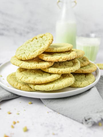 A pile of matcha cookies on a white plate.