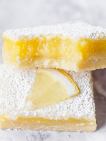 A lemon bar up close with a bite taken out of it.